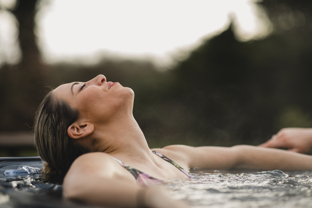 Living Her Best Life Woman relaxing in solar powered hot tub hot tub