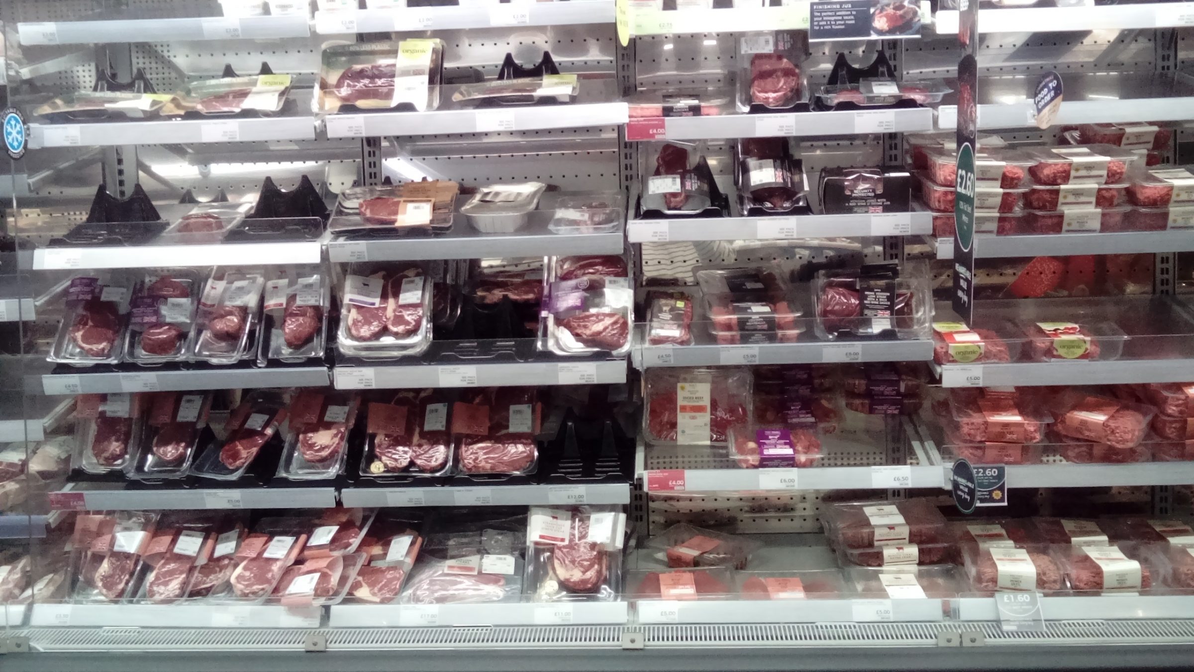 A supermarket fridge with prepacked meat.